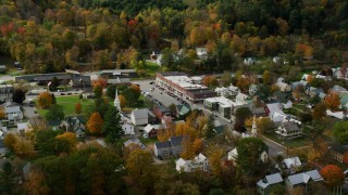 AX150_436 - 5.5K stock footage aerial video orbiting a small rural town and town square with colorful autumn trees, South Royalton, Vermont