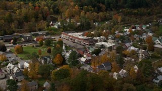 AX150_436E - 5.5K aerial stock footage orbiting a small rural town and town square with colorful autumn trees, South Royalton, Vermont