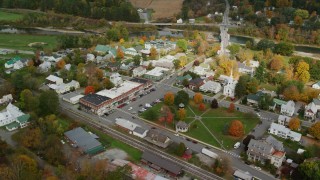 AX150_438 - 5.5K stock footage aerial video orbiting small rural town, town square, churches, shops, autumn, South Royalton, Vermont