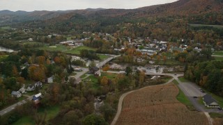 AX150_440E - 5.5K aerial stock footage approaching White River, small bridge, small rural town in autumn, South Royalton, Vermont