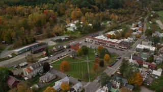 AX150_442E - 5.5K aerial stock footage orbiting colorful foliage throughout small rural town adjacent to the town square, autumn, South Royalton, Vermont