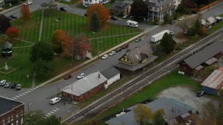 AX150_444 - 5.5K stock footage aerial video orbiting railroad tracks and station, small rural town, autumn, South Royalton, Vermont