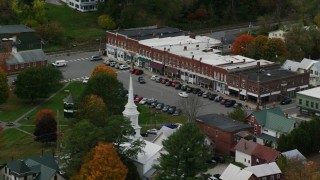 AX150_447 - 5.5K aerial stock footage orbiting a row of shops near town square, small rural town, autumn, South Royalton, Vermont