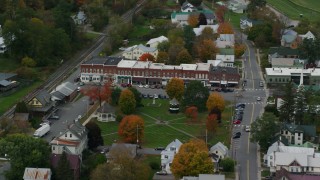 AX150_448 - 5.5K stock footage aerial video flying away from shops and town square in small rural town, autumn, South Royalton, Vermont