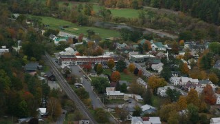 AX150_449 - 5.5K stock footage aerial video flying away from small rural town, shops, town square, autumn, South Royalton, Vermont
