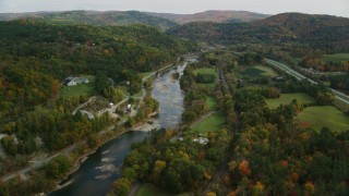 AX150_450 - 5.5K aerial stock footage flying over country roads, approach White River, autumn, South Royalton, Vermont