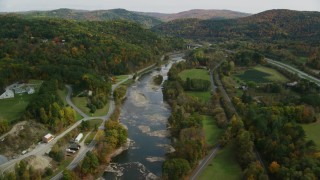 AX150_451 - 5.5K aerial stock footage flying over White River, roads, approaching small bridge, autumn, South Royalton, Vermont
