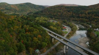 AX150_452 - 5.5K stock footage aerial video flying over White River, approach Interstate 89, small bridge, pan left, autumn, South Royalton, Vermont