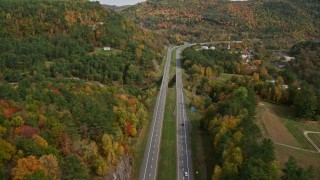 AX150_452E - 5.5K aerial stock footage flying over White River, approach Interstate 89, small bridge, pan left, autumn, South Royalton, Vermont