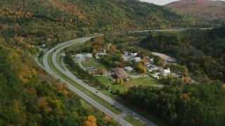 AX150_454 - 5.5K aerial stock footage flying by Interstate 89 through small rural town, autumn, Sharon, Vermont
