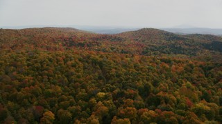 AX150_461 - 5.5K aerial stock footage flying over colorful, densely forested hills in autumn, North Pomfret, Vermont