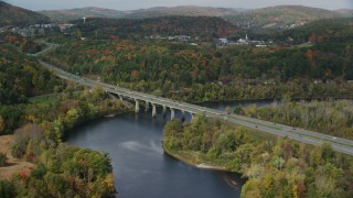 AX150_475 - 5.5K aerial stock footage of Interstate 89, small bridge spanning Connecticut River, autumn, Lebanon, New Hampshire