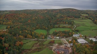 AX151_001 - 5.5K aerial stock footage flying over Hartland Road, approach colorful forested hills, autumn, White River Junction, Vermont
