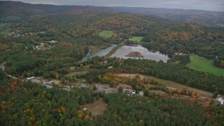 AX151_005 - 5.5K aerial stock footage flying by Dewey's Pond, rural homes, autumn, overcast, Quechee, Vermont