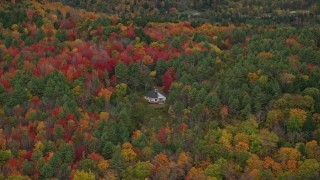 AX151_007 - 5.5K aerial stock footage flying by rural home, dense colorful trees, tilt down, autumn, Quechee, Vermont
