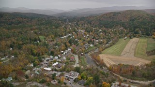 AX151_011E - 5.5K aerial stock footage flying over forest, Blake Hill, reveal, small rural town, autumn, Woodstock, Vermont