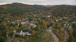 AX151_014E - 5.5K aerial stock footage flying by Ottauquechee River, small rural town, overcast, autumn, Woodstock, Vermont