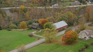 AX151_034 - 5.5K aerial stock footage orbiting a small farm and barn, colorful foliage, autumn, Taftsville, Vermont