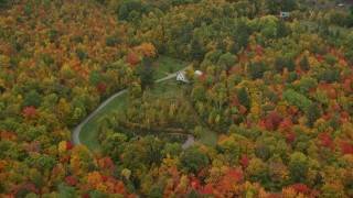 AX151_042 - 5.5K aerial stock footage flying over forest, approach isolated home, tilt down, autumn, Hartland, Vermont