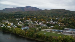 AX151_057 - 5.5K aerial stock footage flying by small rural town, colorful foliage in autumn, overcast, Windsor, Vermont