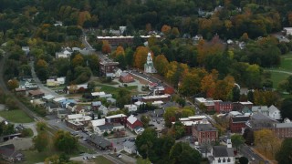 AX151_063 - 5.5K aerial stock footage flying by a small rural town, brightly colored foliage, autumn, Windsor, Vermont