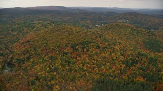 AX151_067 - 5.5K aerial stock footage flying by brightly colored forested hills, autumn, overcast, Cornish, New Hampshire