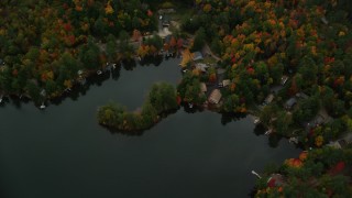 AX151_078 - 5.5K aerial stock footage of a bird's eye view over Perkins Pond, homes, colorful forest, autumn, Sunapee, New Hampshire