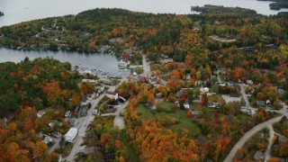 AX151_080 - 5.5K aerial stock footage flying over small rural town, pan to Sunapee Harbor, autumn, Sunapee, New Hampshire