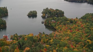 AX151_082 - 5.5K aerial stock footage approaching waterfront mansion, small island, Lake Sunapee, autumn, Sunapee, New Hampshire