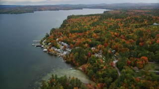 AX151_086 - 5.5K aerial stock footage orbiting waterfront homes, Lake Sunapee, forest, autumn, Newbury, New Hampshire