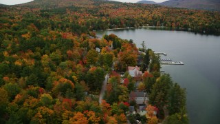 AX151_088 - 5.5K aerial stock footage orbiting colorful forest, waterfront homes, Lake Sunapee, autumn, Newbury, New Hampshire