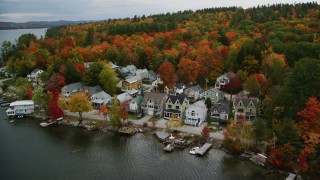 AX151_091 - 5.5K aerial stock footage flying by waterfront homes, Lake Sunapee, autumn, Newbury, New Hampshire