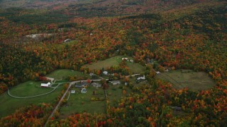 AX151_109 - 5.5K aerial stock footage approaching rural homes, overcast skies, colorful trees, autumn, Wilmot, New Hampshire