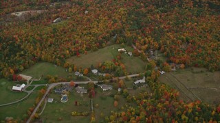AX151_109E - 5.5K aerial stock footage approaching rural homes, overcast skies, colorful trees, autumn, Wilmot, New Hampshire