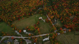 AX151_110 - 5.5K aerial stock footage of a bird's eye view over rural homes, dense, colorful forest, autumn, Wilmot, New Hampshire
