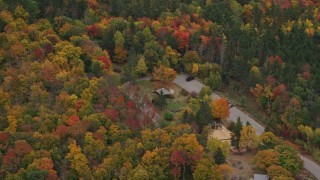 AX151_111 - 5.5K aerial stock footage flying by parking area, brightly colored forrest, autumn, Wilmot, New Hampshire