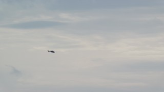 AX151_113 - 5.5K aerial stock footage tracking a military helicopter across the overcast sky, Wilmot, New Hampshire