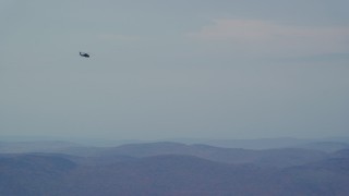 AX151_114 - 5.5K aerial stock footage tracking military helicopter across cloudy, overcast sky, Wilmot, New Hampshire