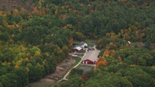 AX151_121 - 5.5K aerial stock footage flying by barns, colorful trees in autumn, Warner, New Hampshire