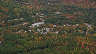 AX151_122E - 5.5K aerial stock footage flying by small rural town, colorful foliage, autumn, Warner, New Hampshire