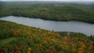 AX151_127 - 5.5K aerial stock footage flying over Lake Winnepocket, dense forest, autumn, overcast, Webster, New Hampshire