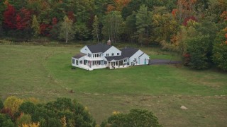 AX151_129 - 5.5K aerial stock footage flying by an isolated home, colorful foliage in autumn, Webster, New Hampshire