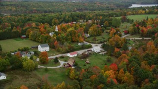AX151_134 - 5.5K aerial stock footage orbiting brightly colored foliage, a small rural town, church,  Webster, New Hampshire