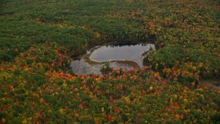 AX151_139 - 5.5K aerial stock footage approaching Little Pond, colorful trees, autumn, tilt down, Webster, New Hampshire