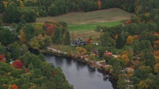 AX151_141 - 5.5K aerial stock footage flying by waterfront homes, Contoocook River, autumn, Penacook, New Hampshire