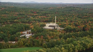 AX151_153 - 5.5K aerial stock footage flying by factory, smoke stack, colorful trees in autumn, Penacook, New Hampshire