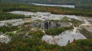AX151_162 - 5.5K aerial stock footage orbiting brightly colored foliage, quarry in autumn, Concord, New Hampshire