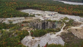 AX151_162E - 5.5K aerial stock footage orbiting brightly colored foliage, quarry in autumn, Concord, New Hampshire