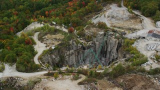 AX151_164 - 5.5K aerial stock footage orbiting a quarry, large cranes, colorful foliage in autumn, Concord, New Hampshire