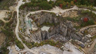 AX151_165E - 5.5K aerial stock footage orbiting cranes, quarry, colorful foliage in autumn, Concord, New Hampshire